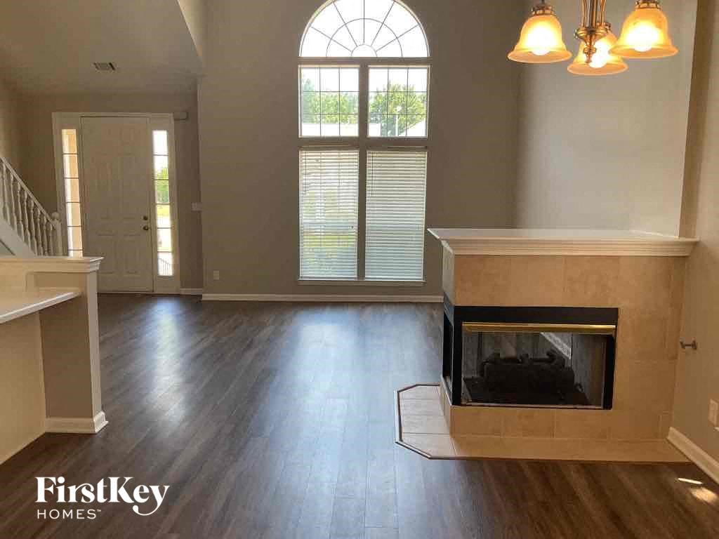 A living room with a fireplace and a large window.