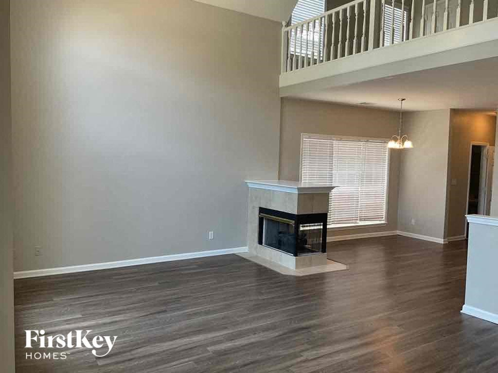A living room with a fireplace and wooden floors.