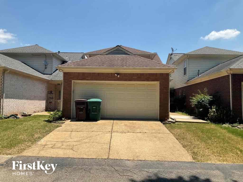 A garage with a brown roof is in the middle of a grassy area.
