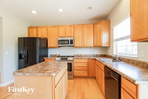a kitchen with wooden cabinets and granite counter tops