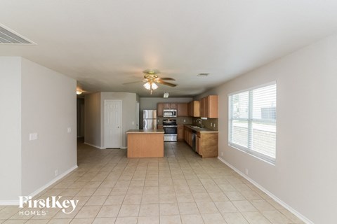 a kitchen and living room with a ceiling fan