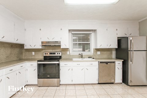 a kitchen with white cabinets and stainless steel appliances