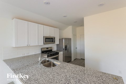 a kitchen with white cabinets and granite counter tops