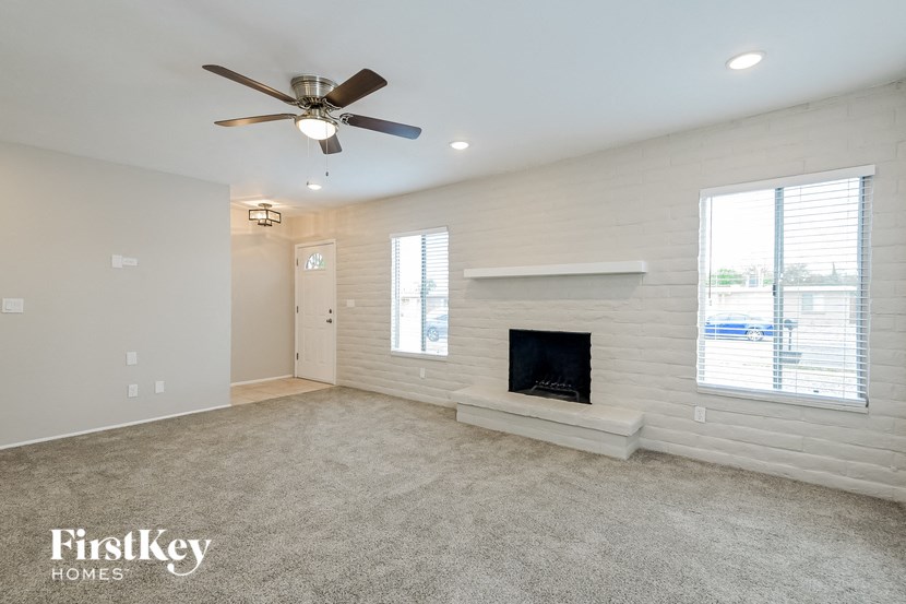 a living room with a fireplace and a ceiling fan
