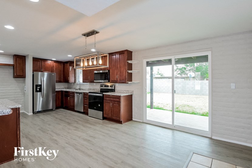 a kitchen with wooden cabinets and a sliding glass door