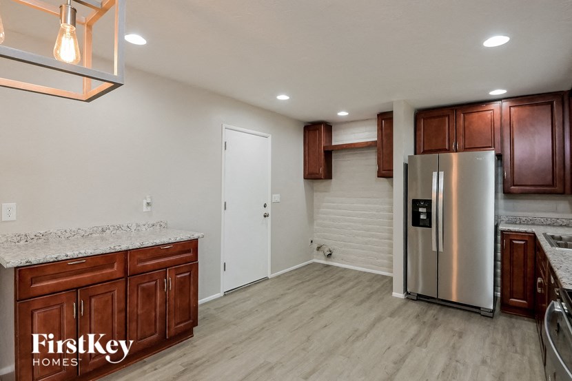 a kitchen with wooden cabinets and a stainless steel refrigerator