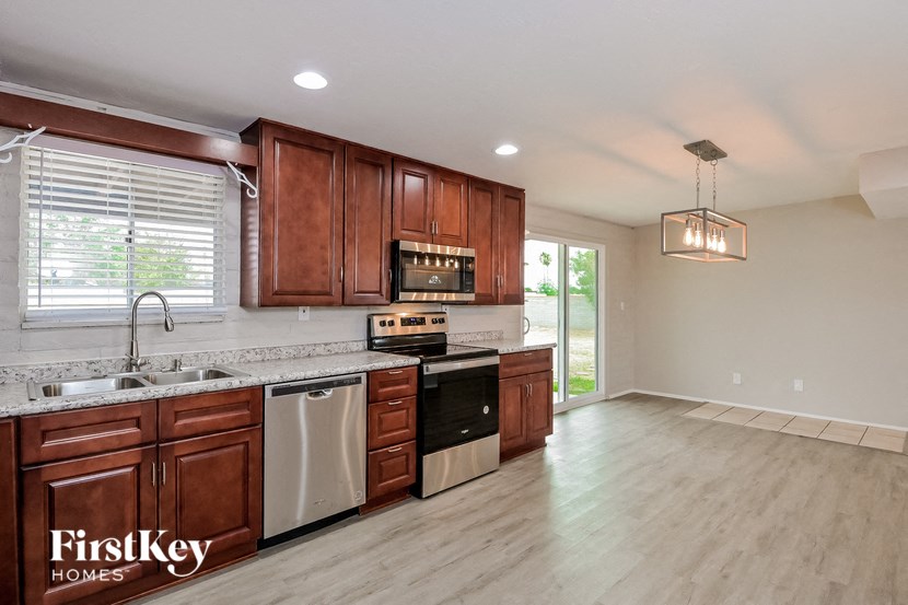 a kitchen with wooden cabinets and a sink and a stove