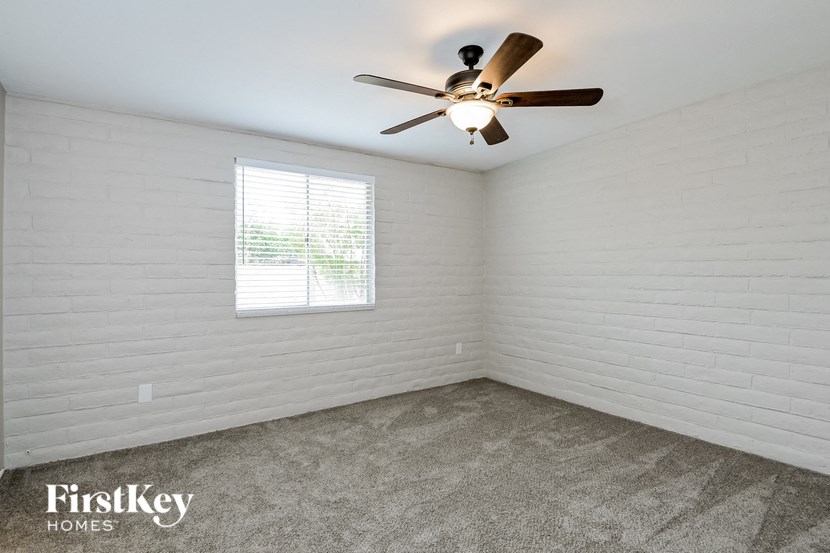 a white room with a ceiling fan and a window