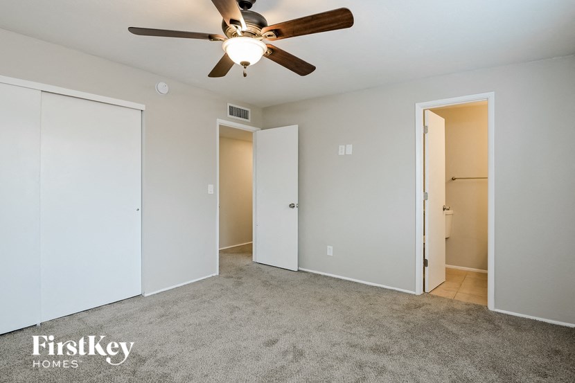 a bedroom with a ceiling fan and a closet