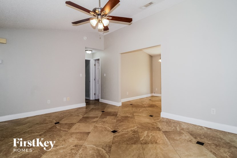A room with a ceiling fan and tile flooring.