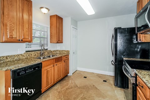 A kitchen with wooden cabinets and black appliances.