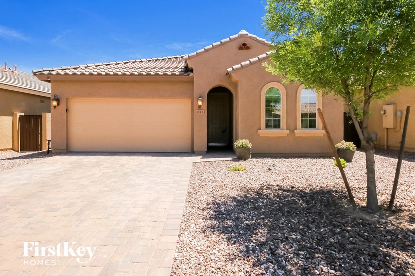 a house with a driveway and a tree