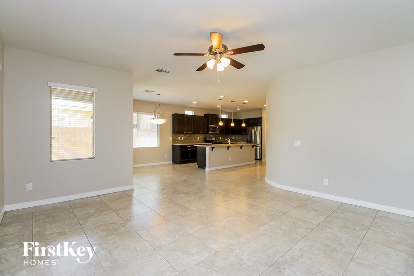 an empty kitchen and living room with a ceiling fan