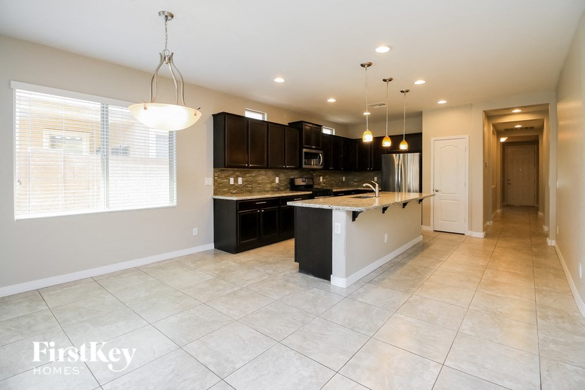 a large kitchen with black cabinets and a white counter top