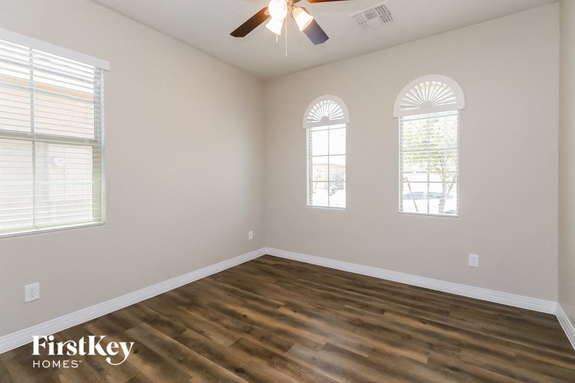 the spacious living room with hardwood flooring and three windows