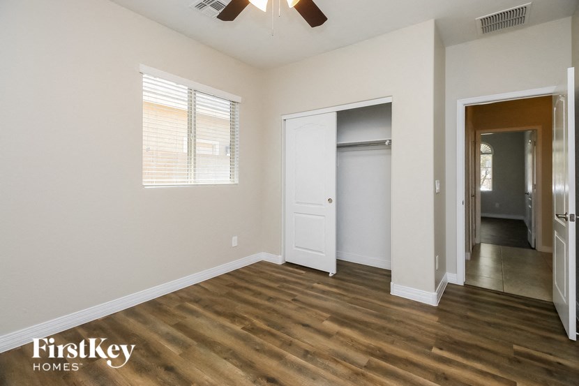 a living room with wood floors and white walls and a closet