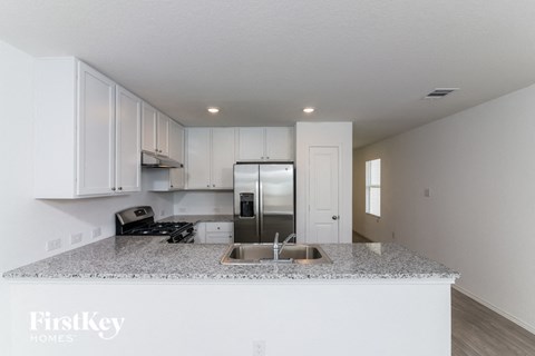 A kitchen with granite countertops and white cabinets.