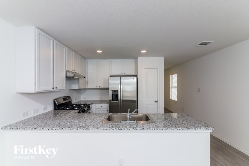 A kitchen with granite countertops and stainless steel appliances.