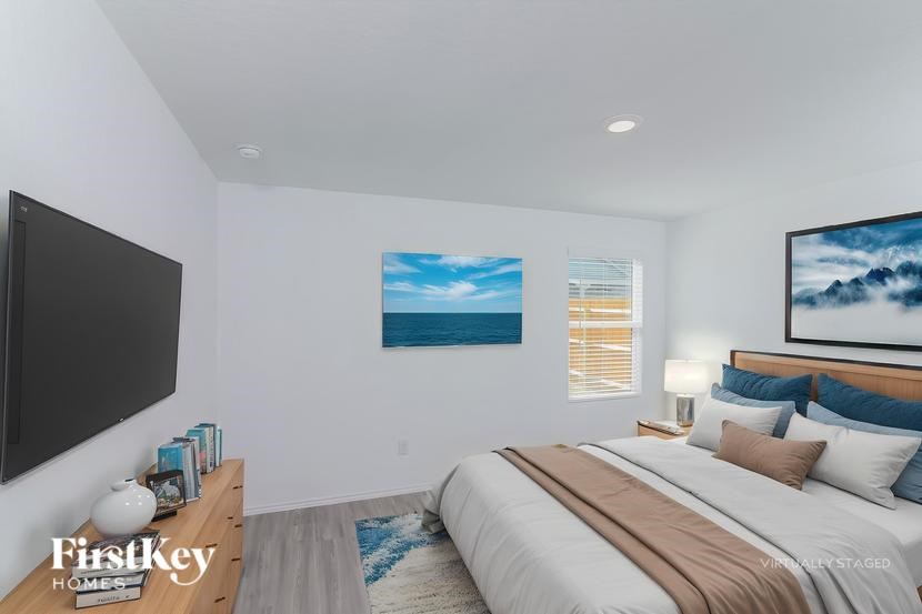 A bedroom with a large bed and a flat screen TV mounted on the wall.