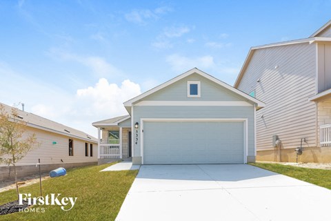 a home with a white driveway and a garage door