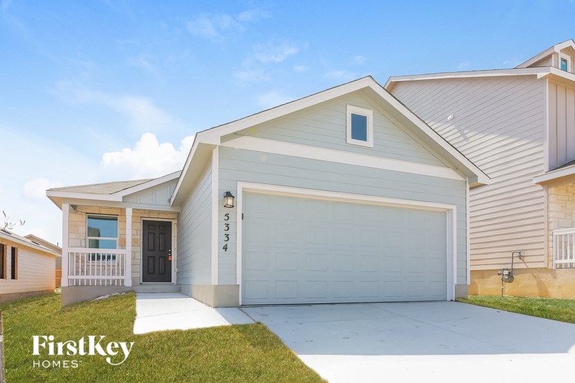 a white house with a garage door and a driveway