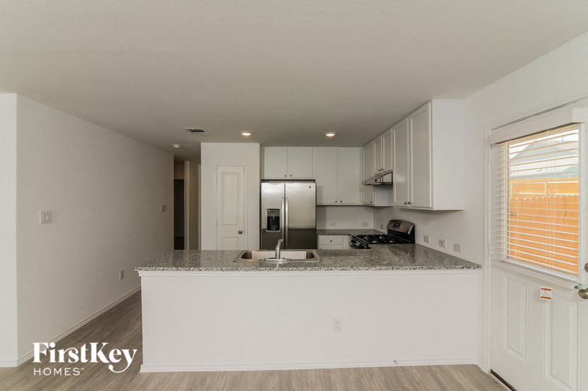 a kitchen with white cabinets and a granite counter top