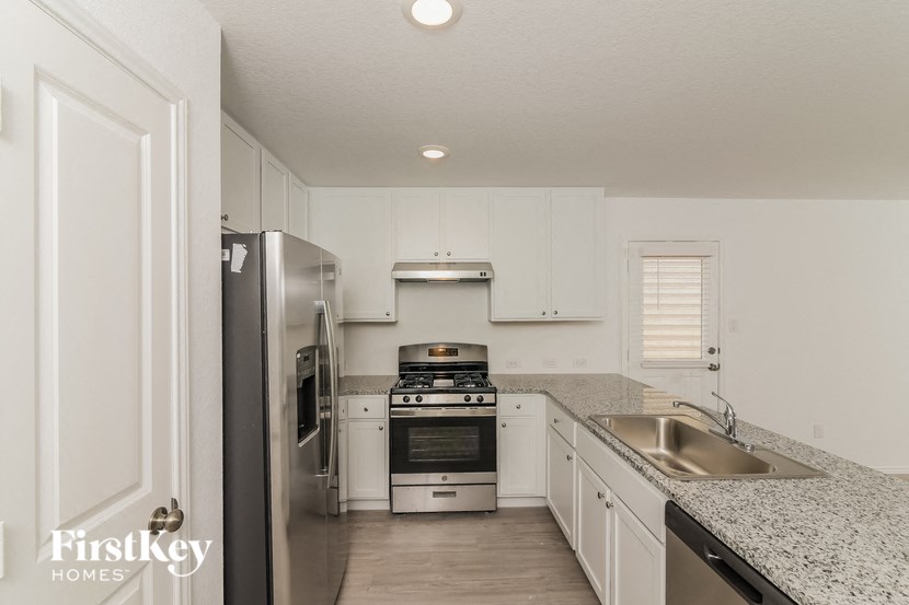 a kitchen with white cabinets and stainless steel appliances