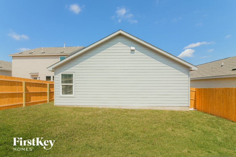 the backyard of a house with a yard and a fence