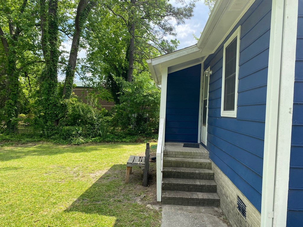 a blue house with a blue door and a porch with a bench