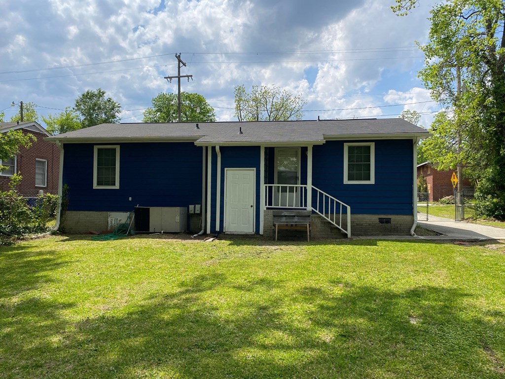 a blue house with a lawn and a white door