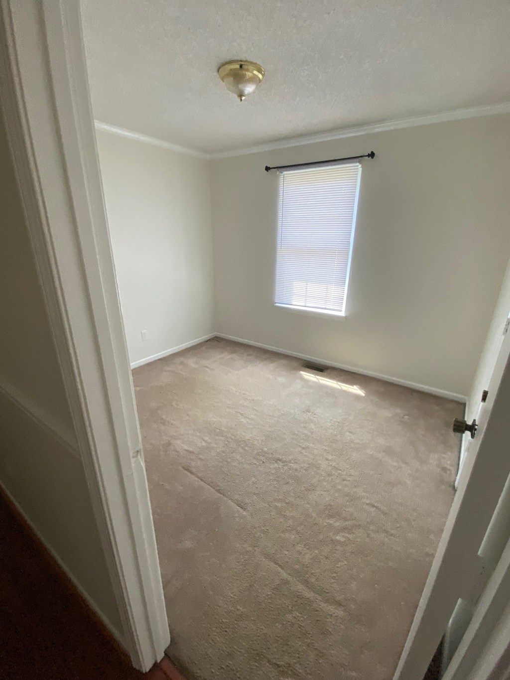 an empty room with white walls and a window