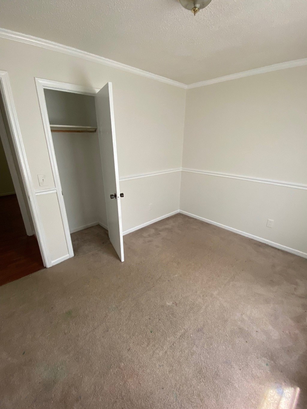 an empty room with carpet and a closet