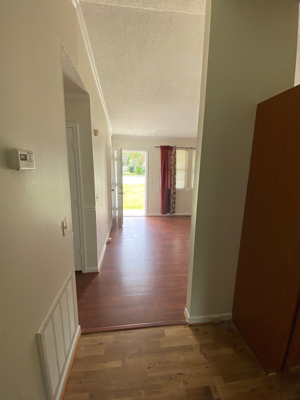 a view from the hallway of a house with a wood floor