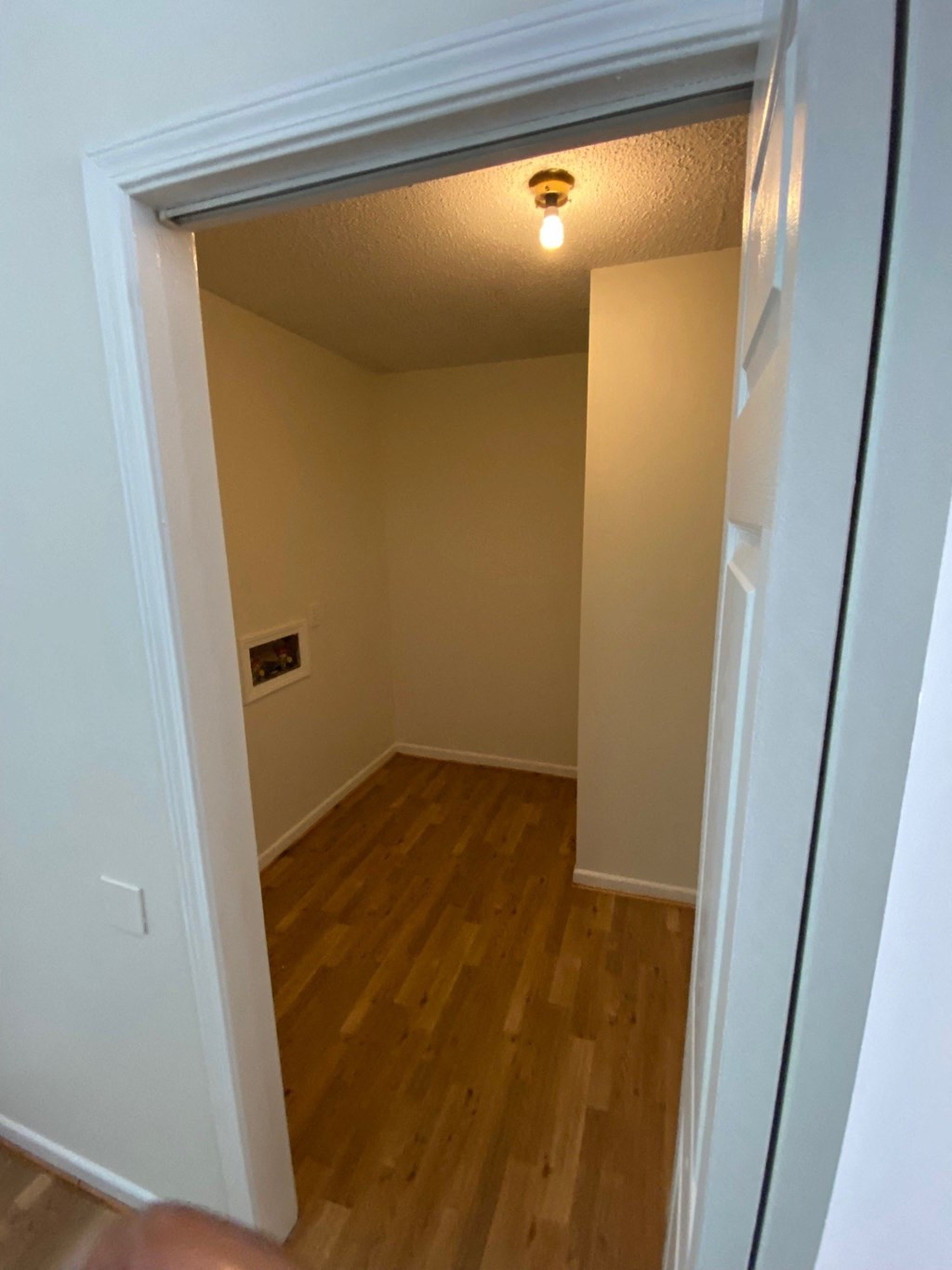 an empty room with a door open and a light on the ceiling