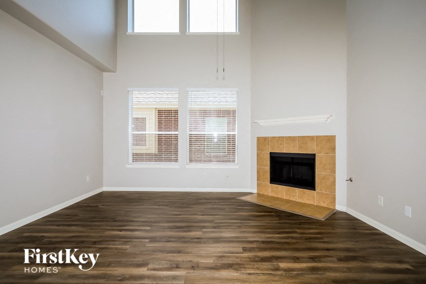 A room with a fireplace and wooden floors.