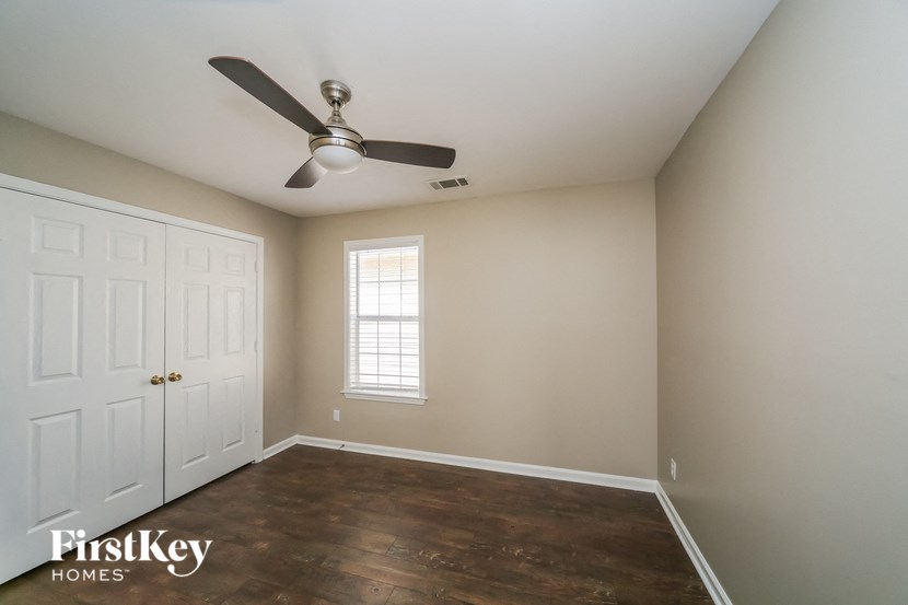 a bedroom with a ceiling fan and a white door