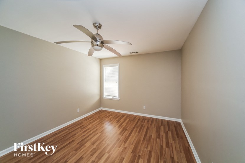 a living room with wood floors and a ceiling fan