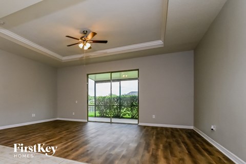 A room with a ceiling fan and wooden flooring.