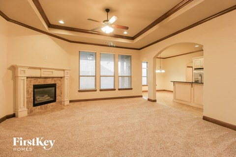 a large living room with a fireplace and a ceiling fan