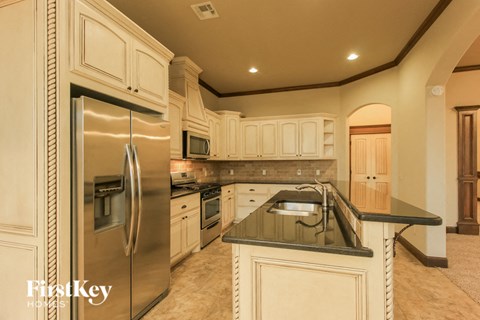a large kitchen with stainless steel appliances and white cabinets