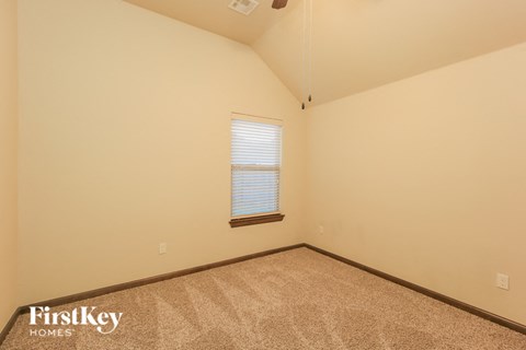 the upstairs bedroom with carpet and a window