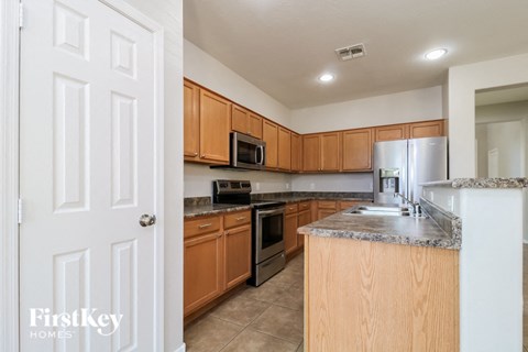 A kitchen with wooden cabinets and a granite countertop.
