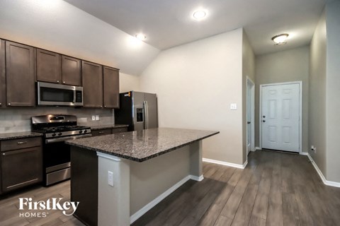 A kitchen with a countertop and a stove top oven.
