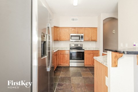 A kitchen with wooden cabinets and a stainless steel refrigerator.