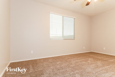 the spacious living room with carpeting and a window