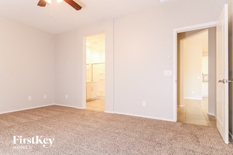 a bedroom with a carpeted floor and a door to a bathroom