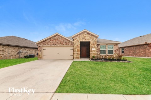 A house with a garage and a driveway in front of it.