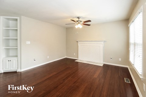 a living room with wood floors and a ceiling fan