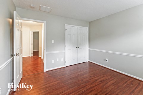 a bedroom with a hard wood floor and white doors