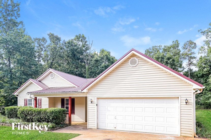 A house with a red roof and a white garage door is for sale.